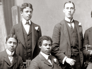 Original: Six musicians posing with their instruments in an archival group photograph